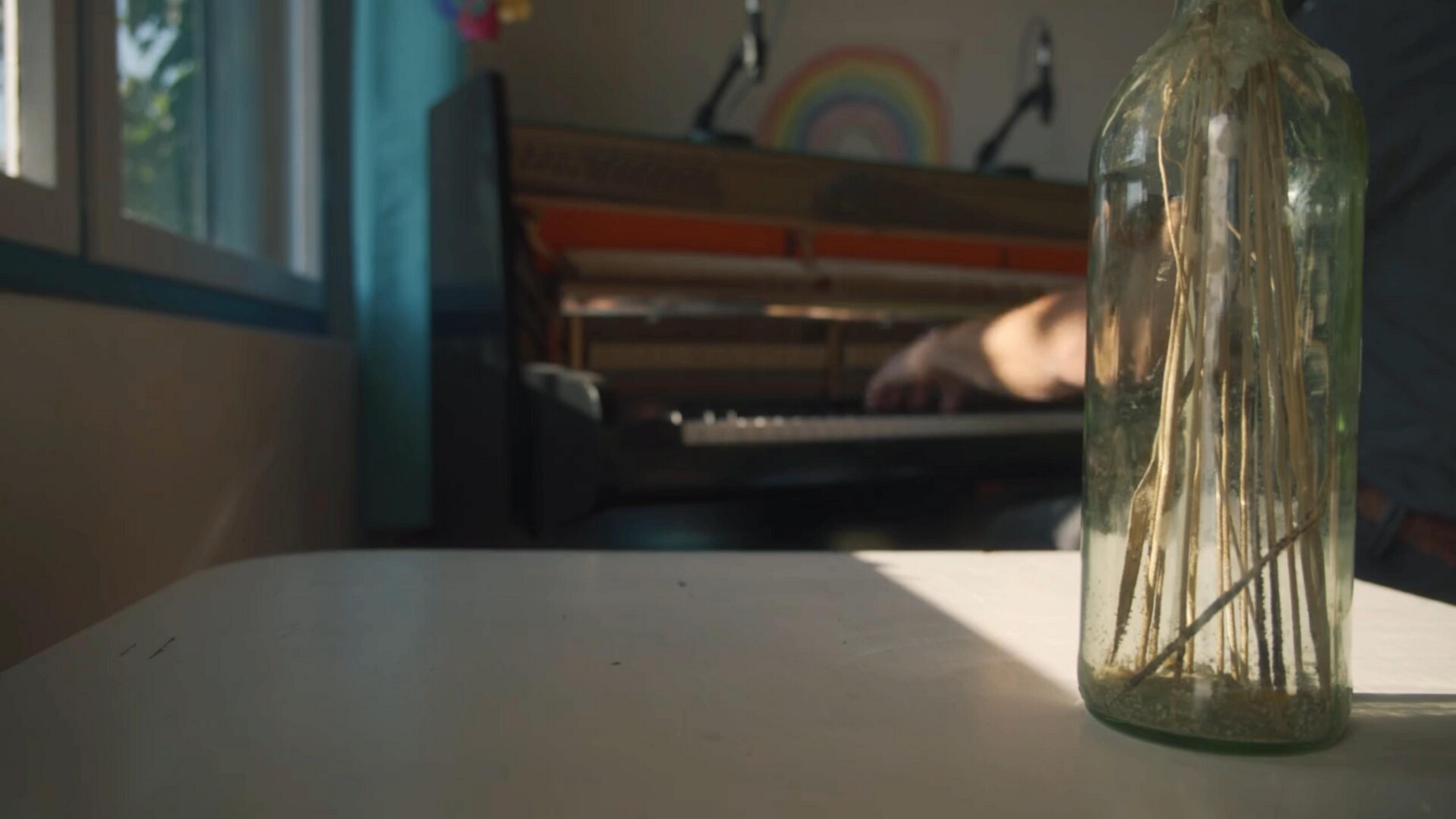 A still life featuring a decorative vase and a softly lit piano, evoking musical inspiration.