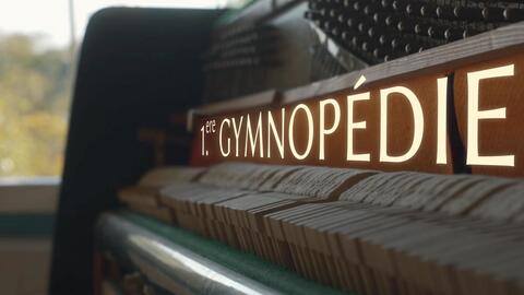 Close-up view of a piano's wooden mechanism bearing the title 1re Gymnopédie.
