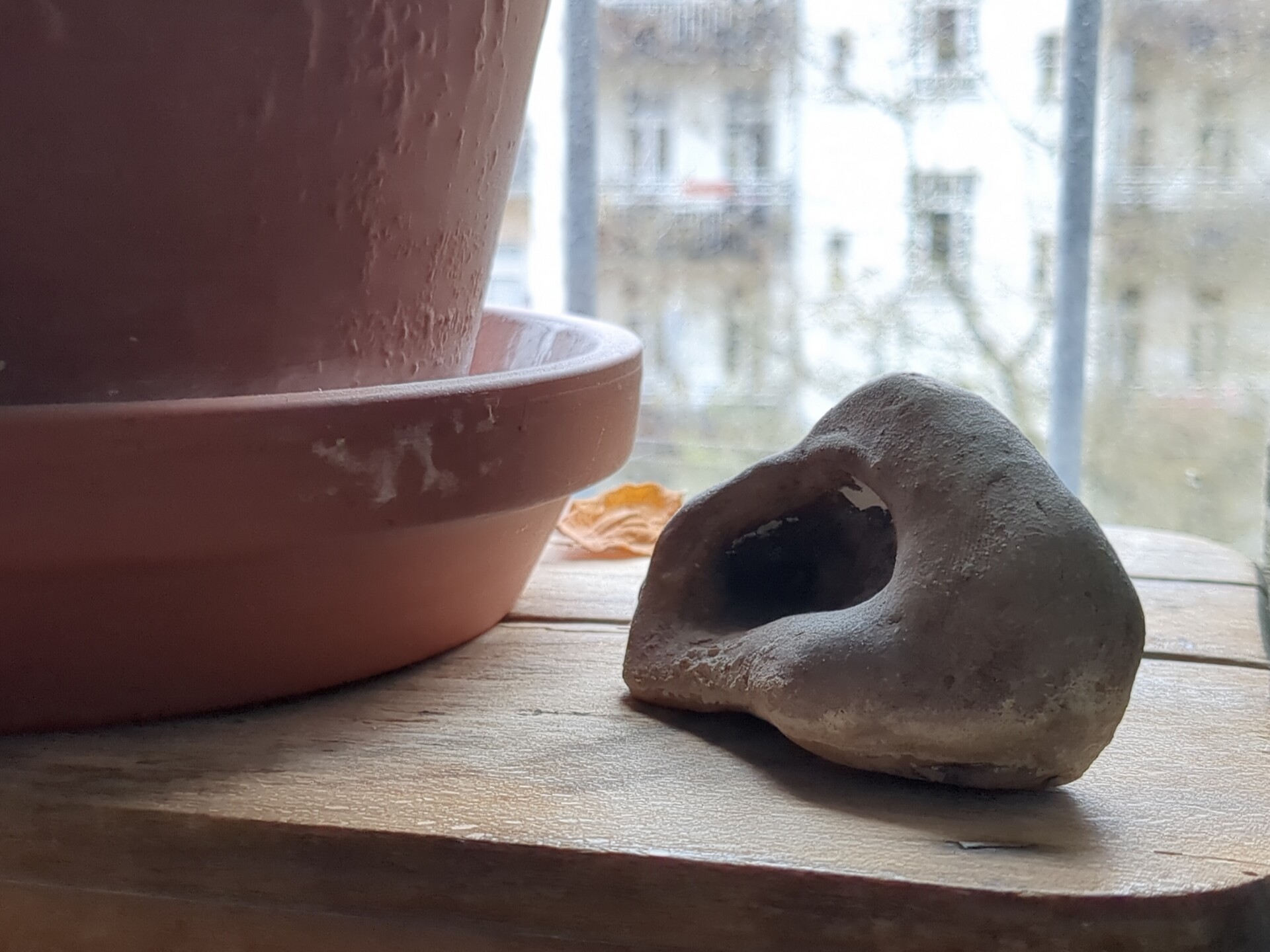 Rustic pottery and natural light arranged on a wooden surface.