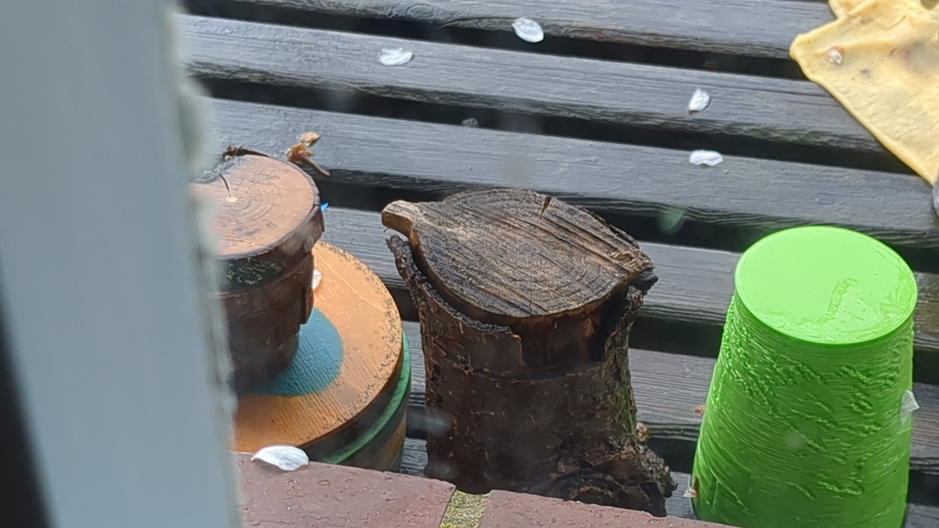 Weathered natural wood forms contrasted with vibrant, painted cylinders.