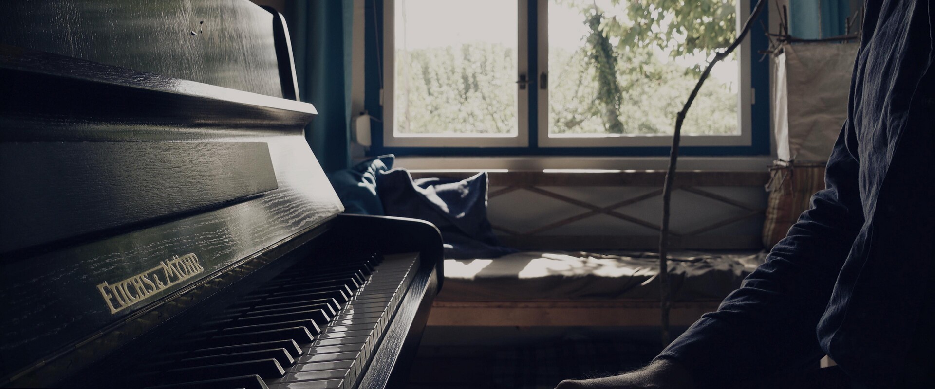 A polished piano bathed in natural light, suggesting a moment of musical contemplation.